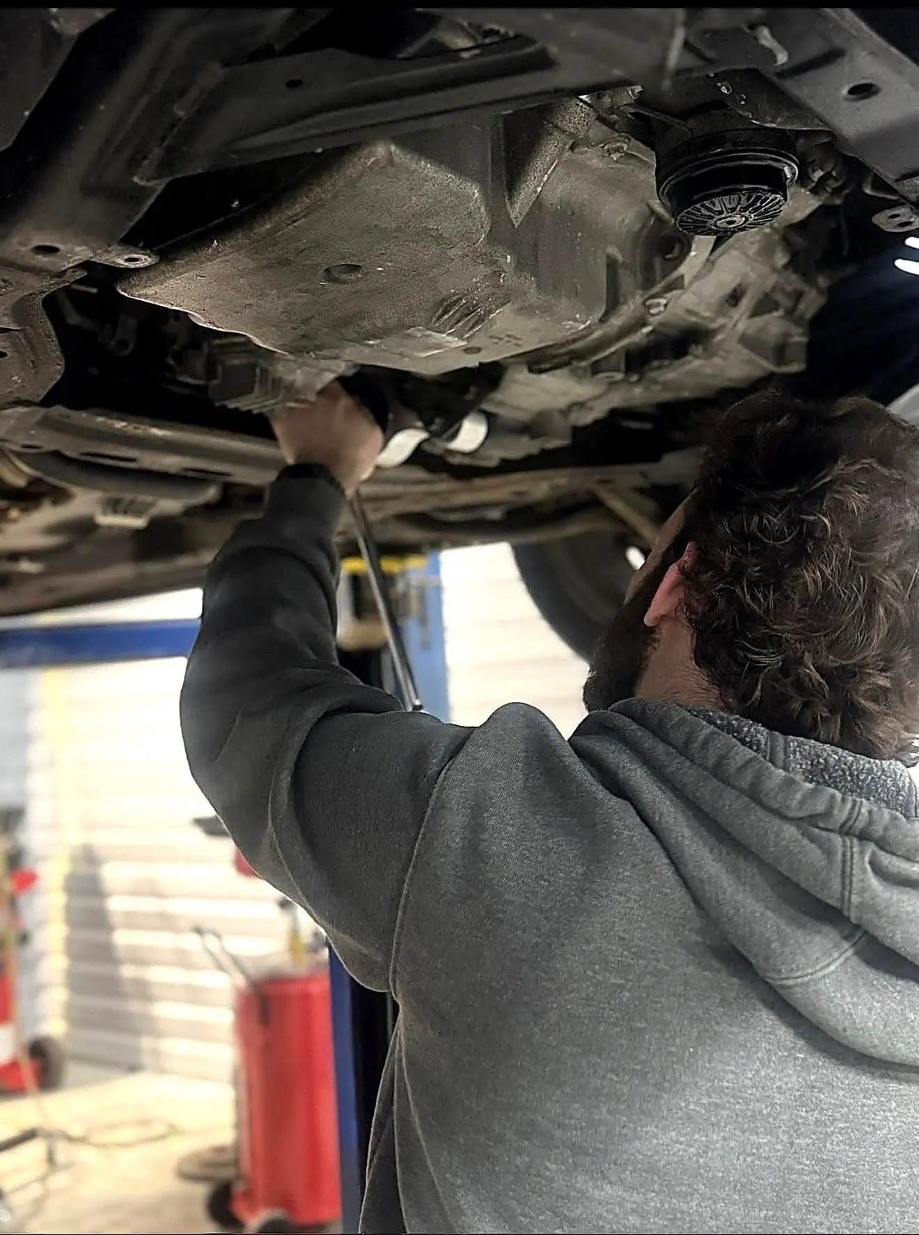 Nick servicing a vehicle undercarriage on a lift